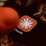 Smartphone displaying Claude AI app icon on screen