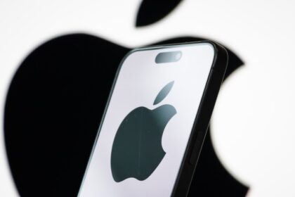 Apple logo displayed on a smartphone screen with stock market graphs in background